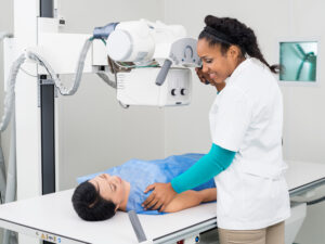 Radiologist Taking X-ray Of Mature Patient Lying On Gurney
