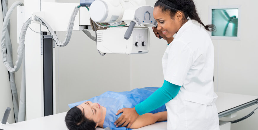 Radiologist Taking X-ray Of Mature Patient Lying On Gurney